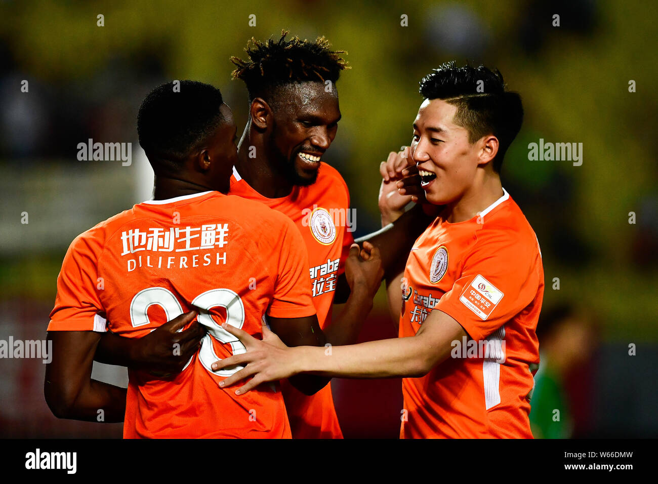 (From left) Cameroonian football player Benjamin Moukandjo, Senegalese football player Makhete Diop and Cao Yongjing of Beijing Renhe celebrate after Stock Photo