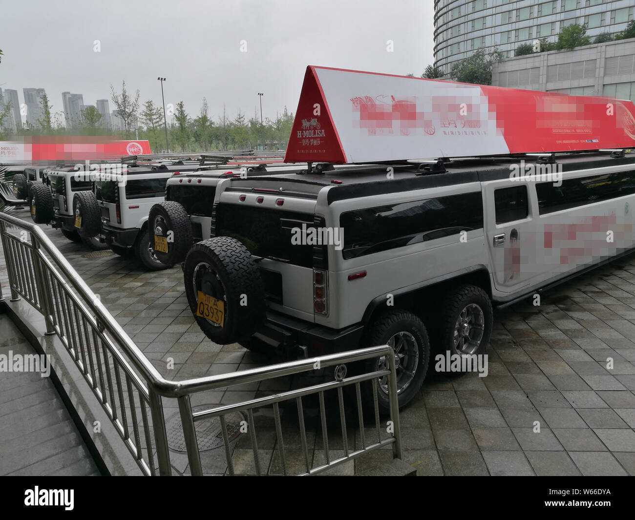 Extended edition Hummer SUVs are lined up in front of an exhibition ...