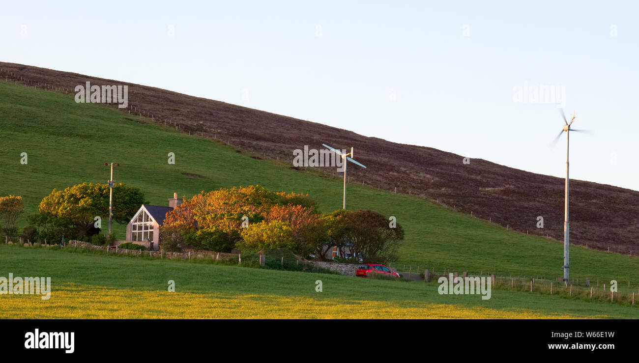 Cottage with wind turbines, Orkney isles Stock Photo