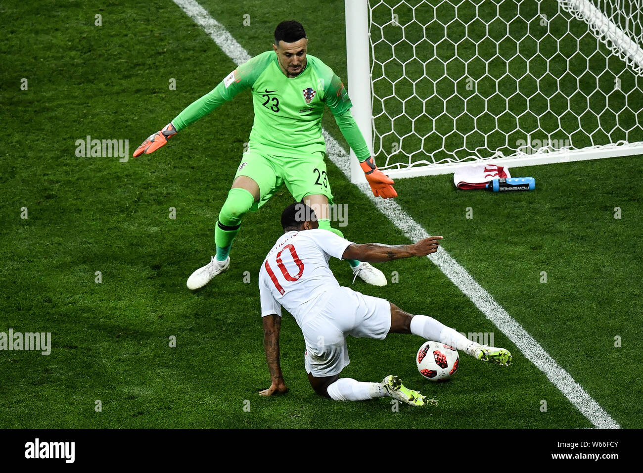 Raheem Sterling of England, front, challenges goalkeeper Danijel Subasic of Croatia in their semifinal match during the 2018 FIFA World Cup in Moscow, Stock Photo
