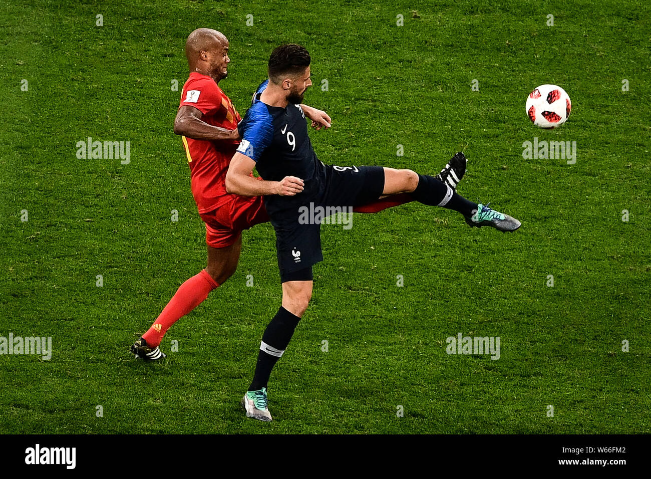 Olivier Giroud of France, front, challenges Vincent Kompany of Belgium in their semifinal match during the 2018 FIFA World Cup in Saint Petersburg, Ru Stock Photo