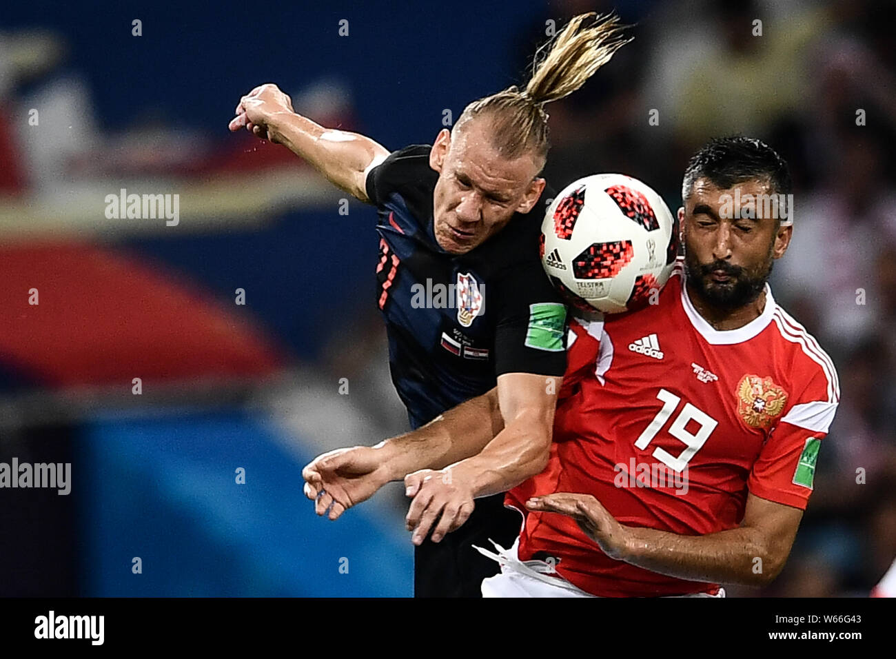 Domagoj Vida of Croatia, left, heads the ball against Aleksandr Samedov of Russia in their quarterfinal match during the 2018 FIFA World Cup in Sochi, Stock Photo