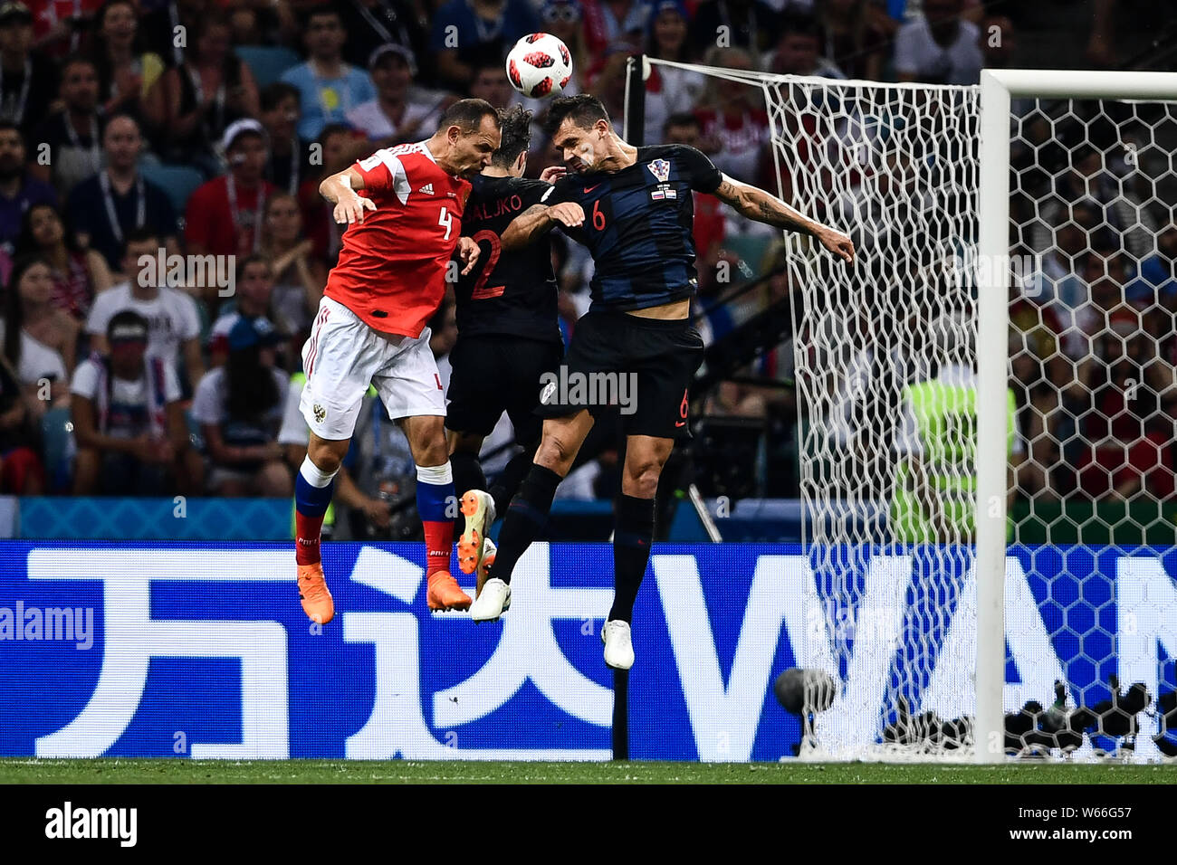 Sergei Ignashevich of Russia, left, heads the ball against Sime Vrsaljko and Dejan Lovren of Croatia with an advertising board for Chinese conglomerat Stock Photo