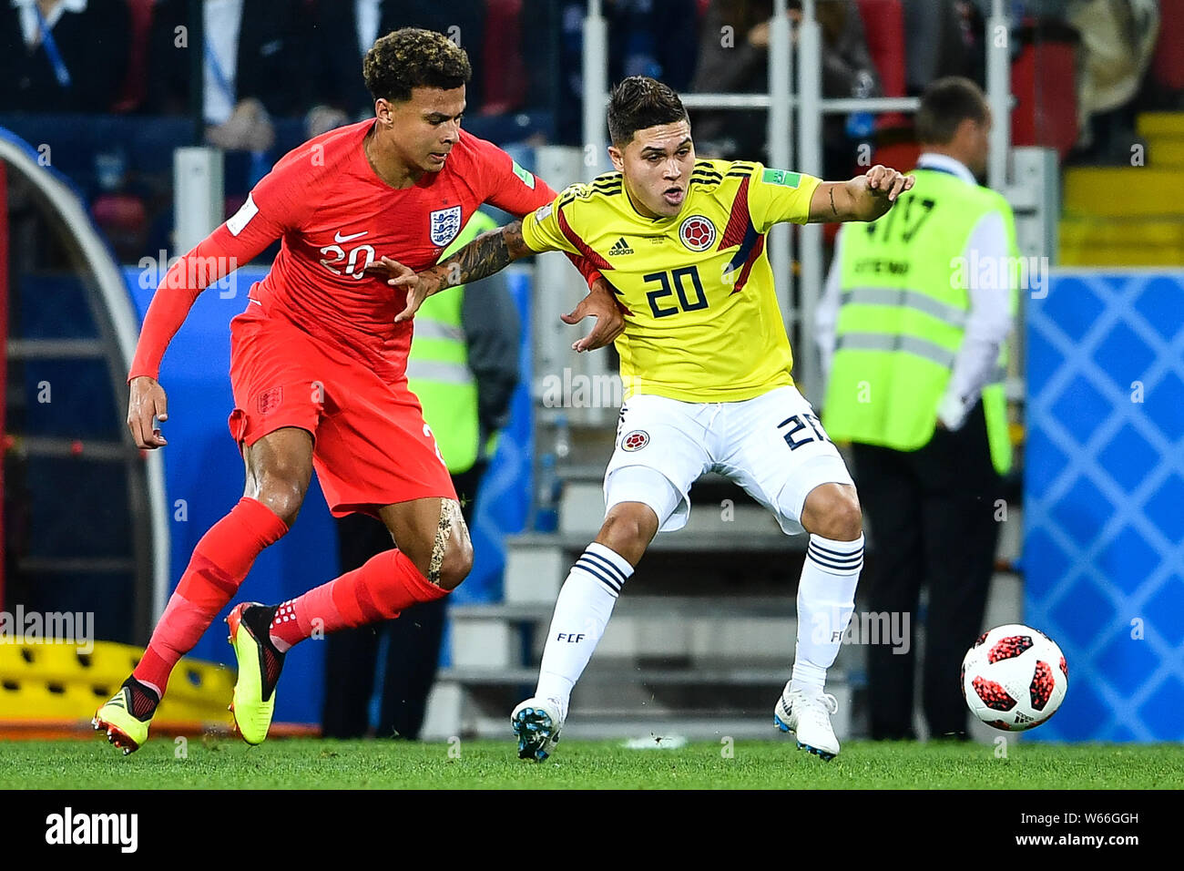 Dele Alli of England, left, challenges Juan Fernando Quintero of Columbia in their Round of 16 match during the 2018 FIFA World Cup in Moscow, Russia, Stock Photo
