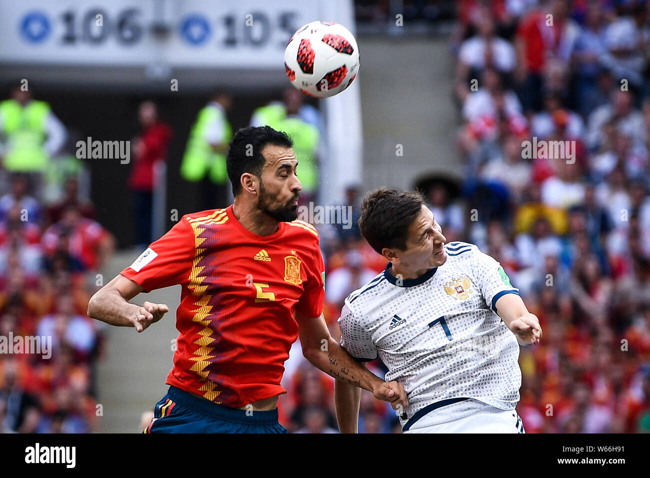 Daler Kuzyayev of Russia, right, heads the ball against Sergio Busquets of Spain in their Round of 16 match during the 2018 FIFA World Cup in Moscow, Stock Photo