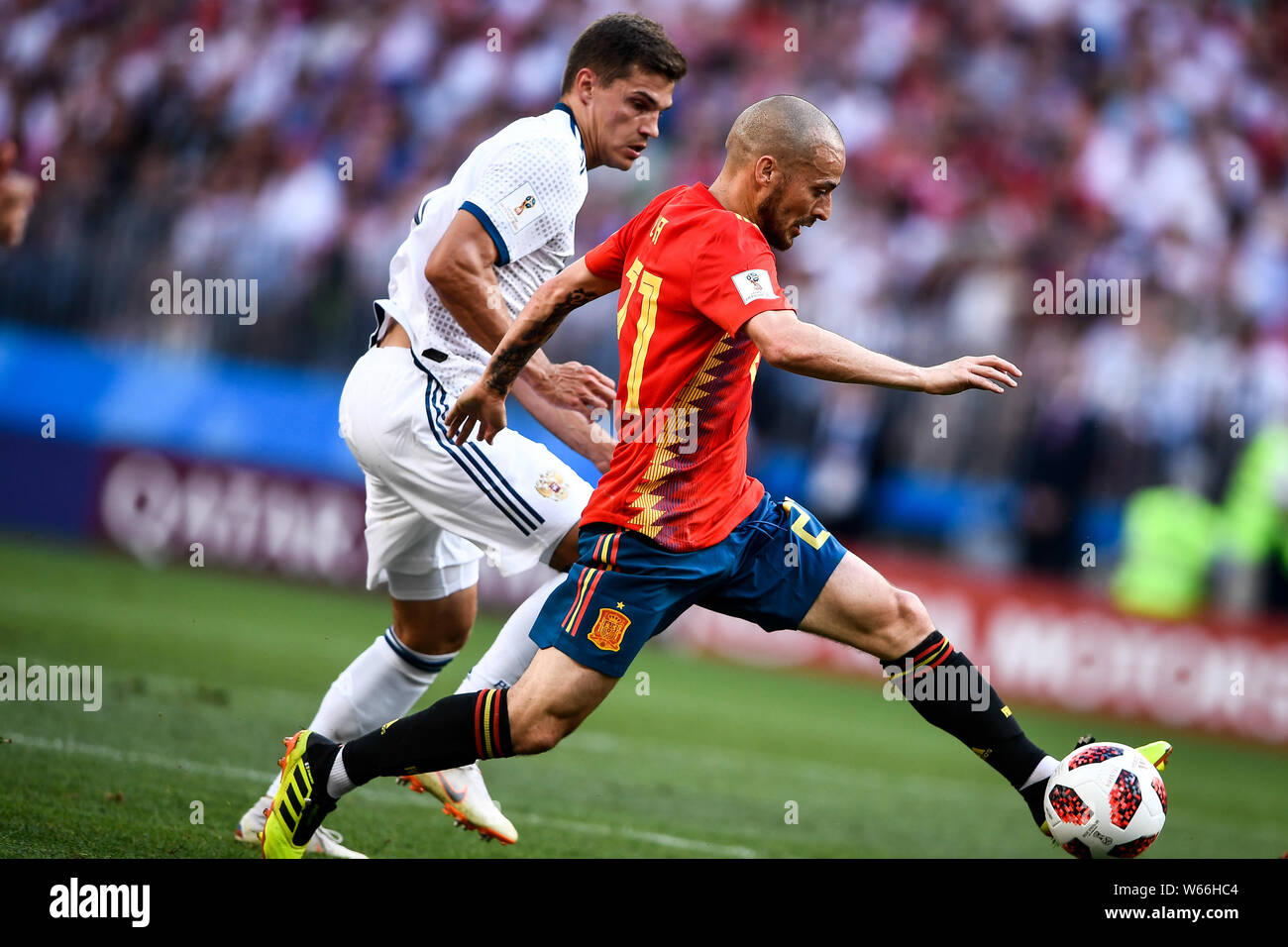 A player of Russia, left, challenges David Silva of Spain in their Round of 16 match during the 2018 FIFA World Cup in Moscow, Russia, 1 July 2018. Stock Photo