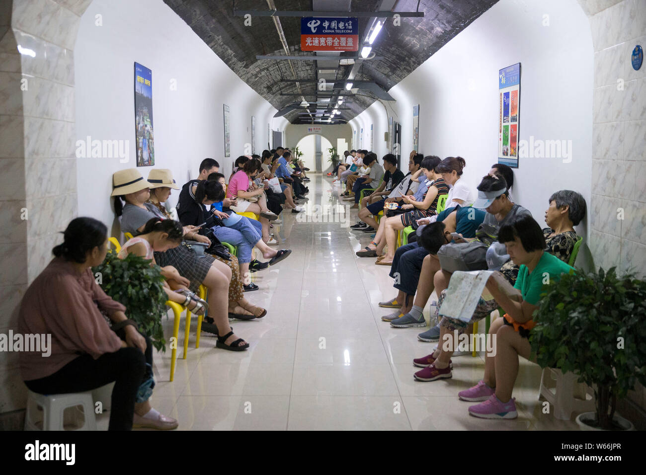 Local residents enjoy themselves in an air-raid shelter to escape summer heat in Nanjing city, east China's Jiangsu province, 15 July 2018.    Residen Stock Photo