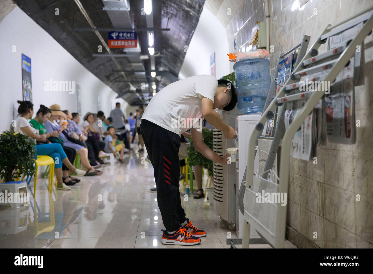 Local residents enjoy themselves in an air-raid shelter to escape summer heat in Nanjing city, east China's Jiangsu province, 15 July 2018.    Residen Stock Photo