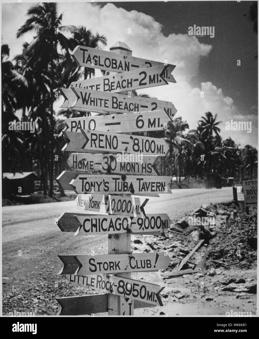 It doesn't seem to matter where the war has carried the GI. He retains a keen sense of humor and an equally sharp yearning for home. Signpost at a crossroads in Tacloban on Leyte reflects Joe's love of a gag and names and places he misses.; General notes:  Use War and Conflict Number 1213 when ordering a reproduction or requesting information about this image. Stock Photo