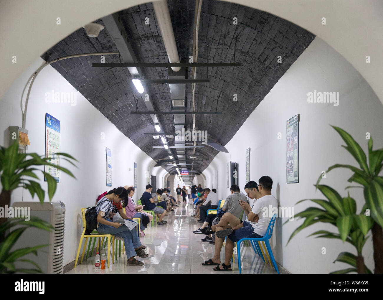 Local residents enjoy themselves in an air-raid shelter to escape summer heat in Nanjing city, east China's Jiangsu province, 15 July 2018.    Residen Stock Photo