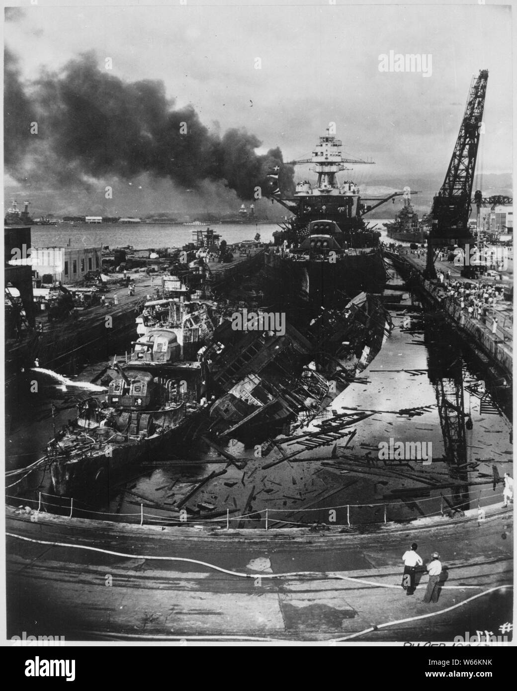 Japanese attack on Pearl Harbor. Wrecked USS DOWNES at left and USS CASSIN at right. In the rear is the USS PENNSYLVANIA, 33,100-ton Flagship of the Pacific Fleet, which suffered only light damage.; Scope and content:  The wartime censor has removed Pennsylvania´s CXAM radar antenna General notes:  Use War and Conflict Number 1138 when ordering a reproduction or requesting information about this image. Stock Photo