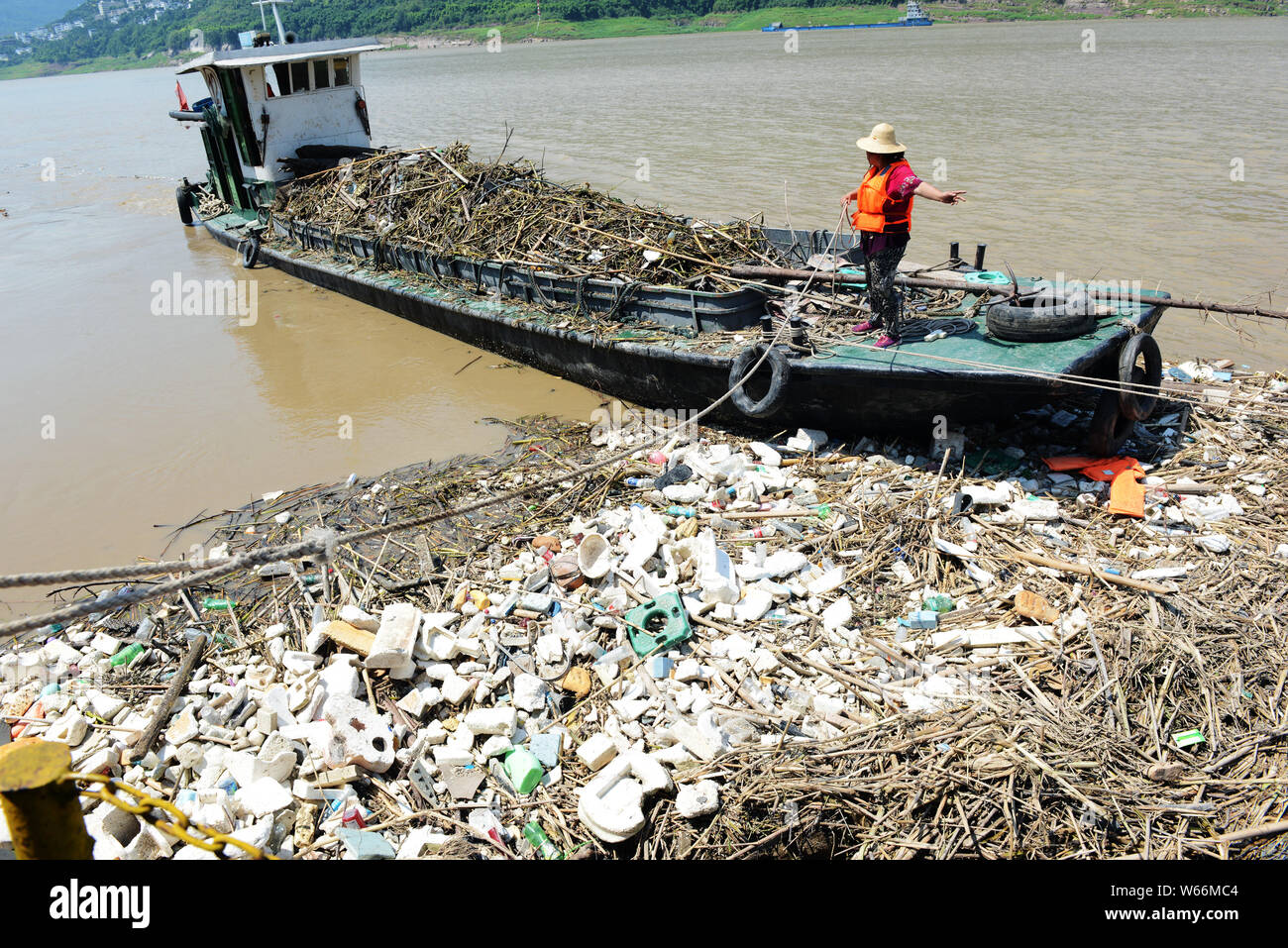 A Chinese worker collects garbage floating on the Yangtze River in ...