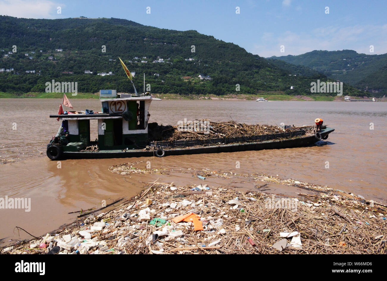 A Chinese worker collects garbage floating on the Yangtze River in ...
