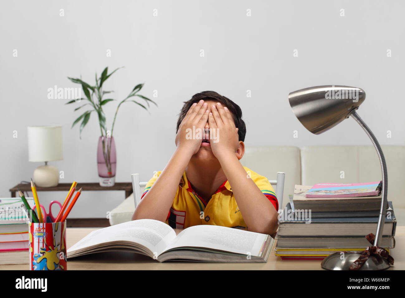 Boy looking tired while reading a book Stock Photo Alamy