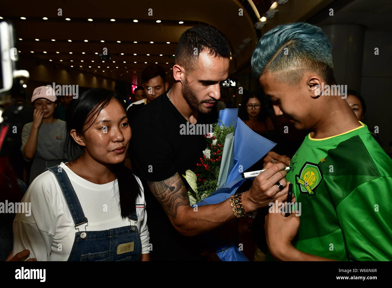 Brazilian football player Renato Soares de Oliveira Augusto, or simply Renato Augusto, of Beijing Sinobo Guoan, signs autographs for Chinese fans as h Stock Photo