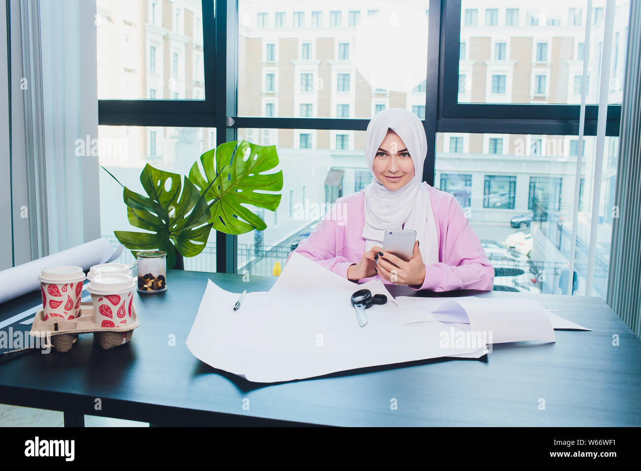 portrait of young attractive muslim woman fashion designer in her workshop smiling to camera. Stock Photo