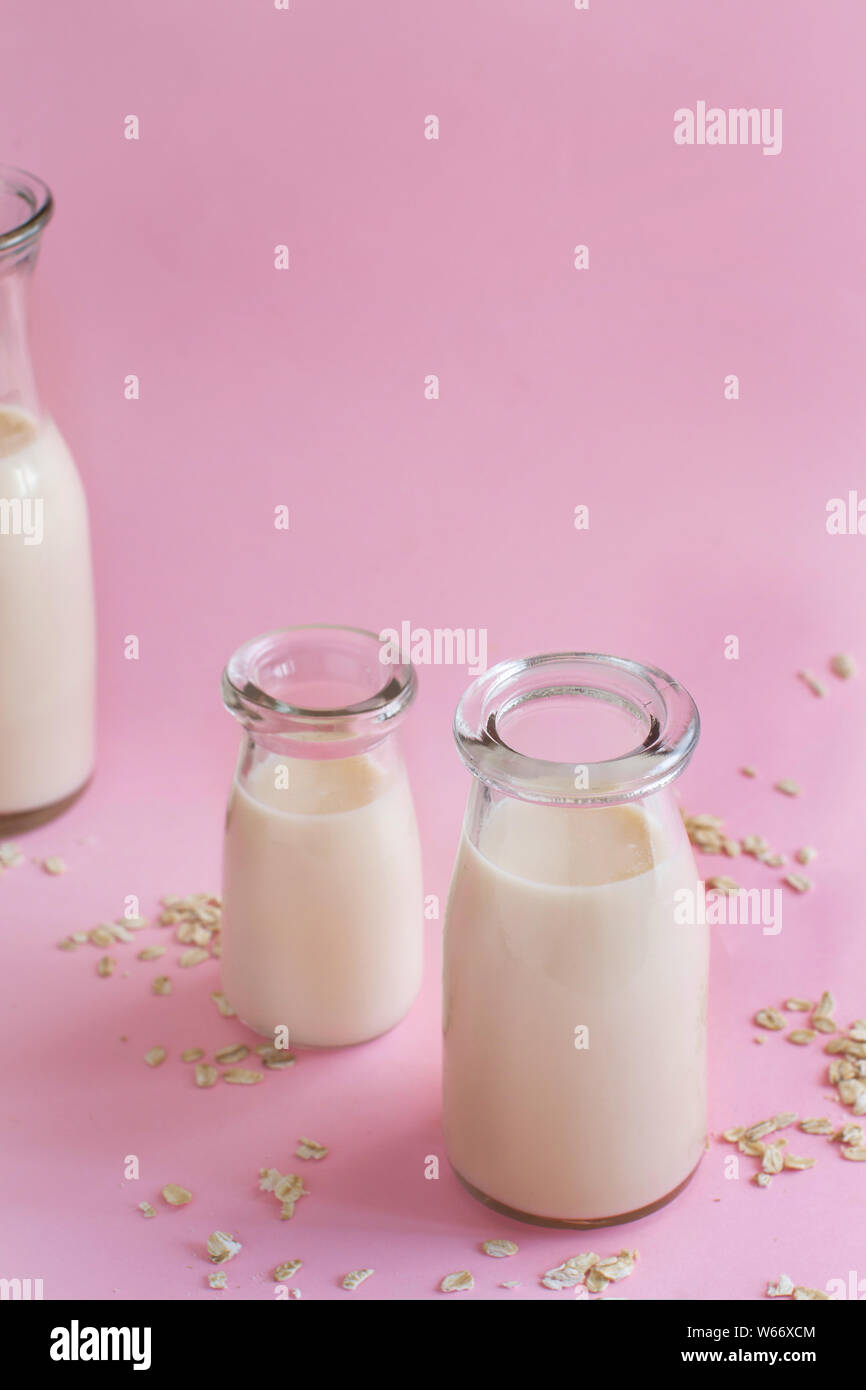 Vegan oat milk, non dairy alternative milk on a light pink background Stock Photo