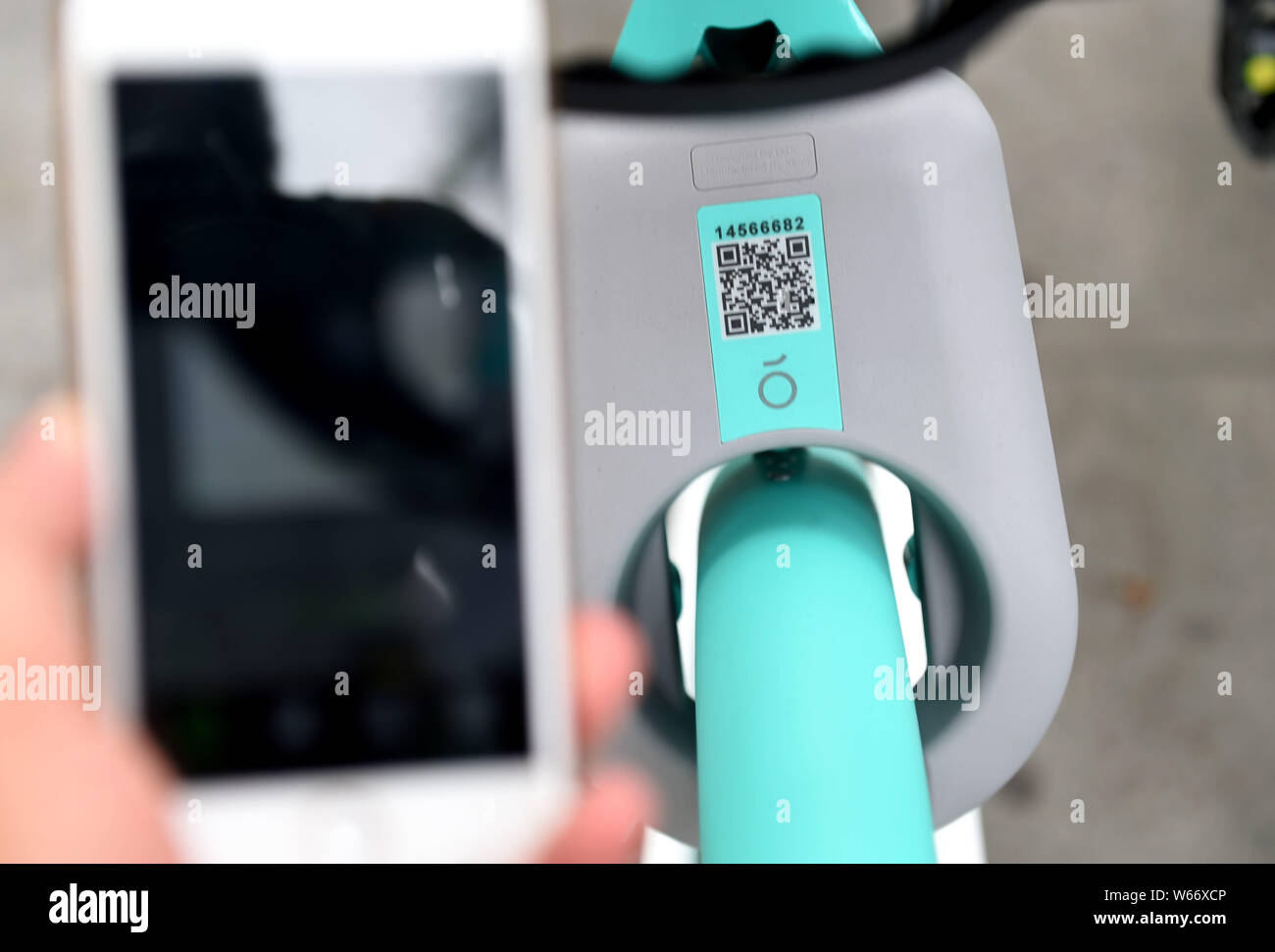 A local resident uses his smartphone to scan the QR code on a Qingju ...