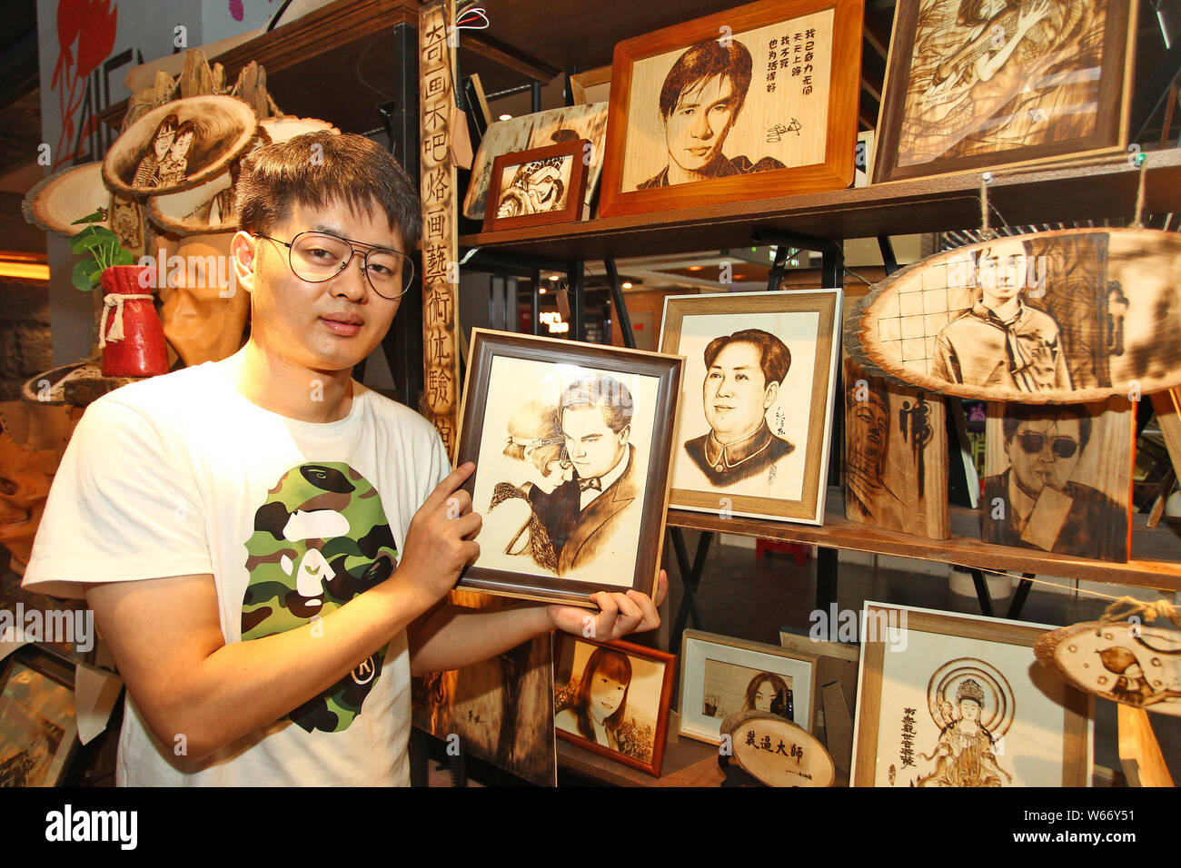 27-year-old Chinese man Peng Fang displays an art work of pyrography at ...
