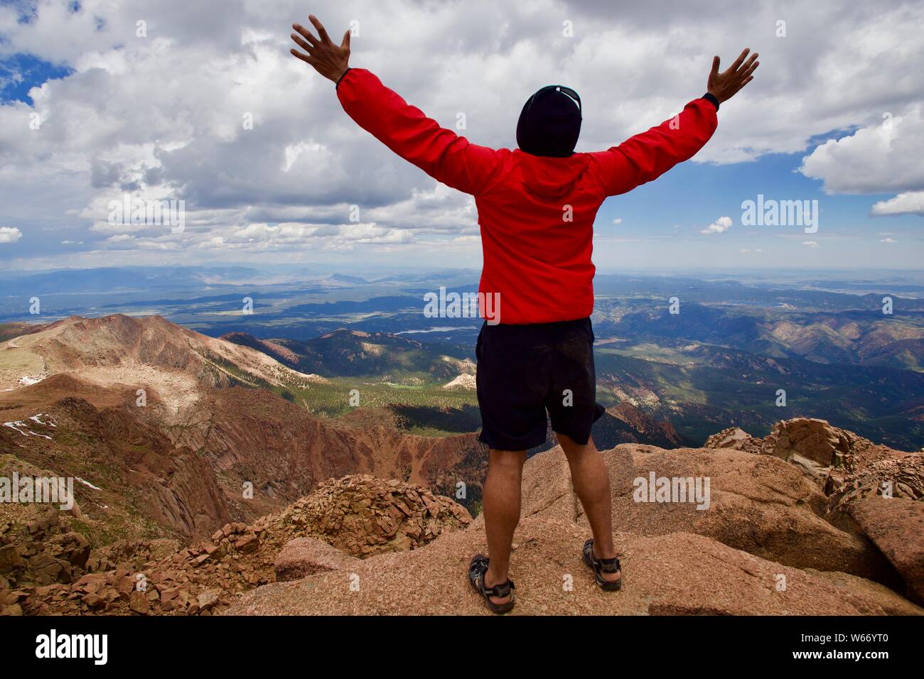 Hispanic man at Pikes Peak with arms in the air Stock Photo
