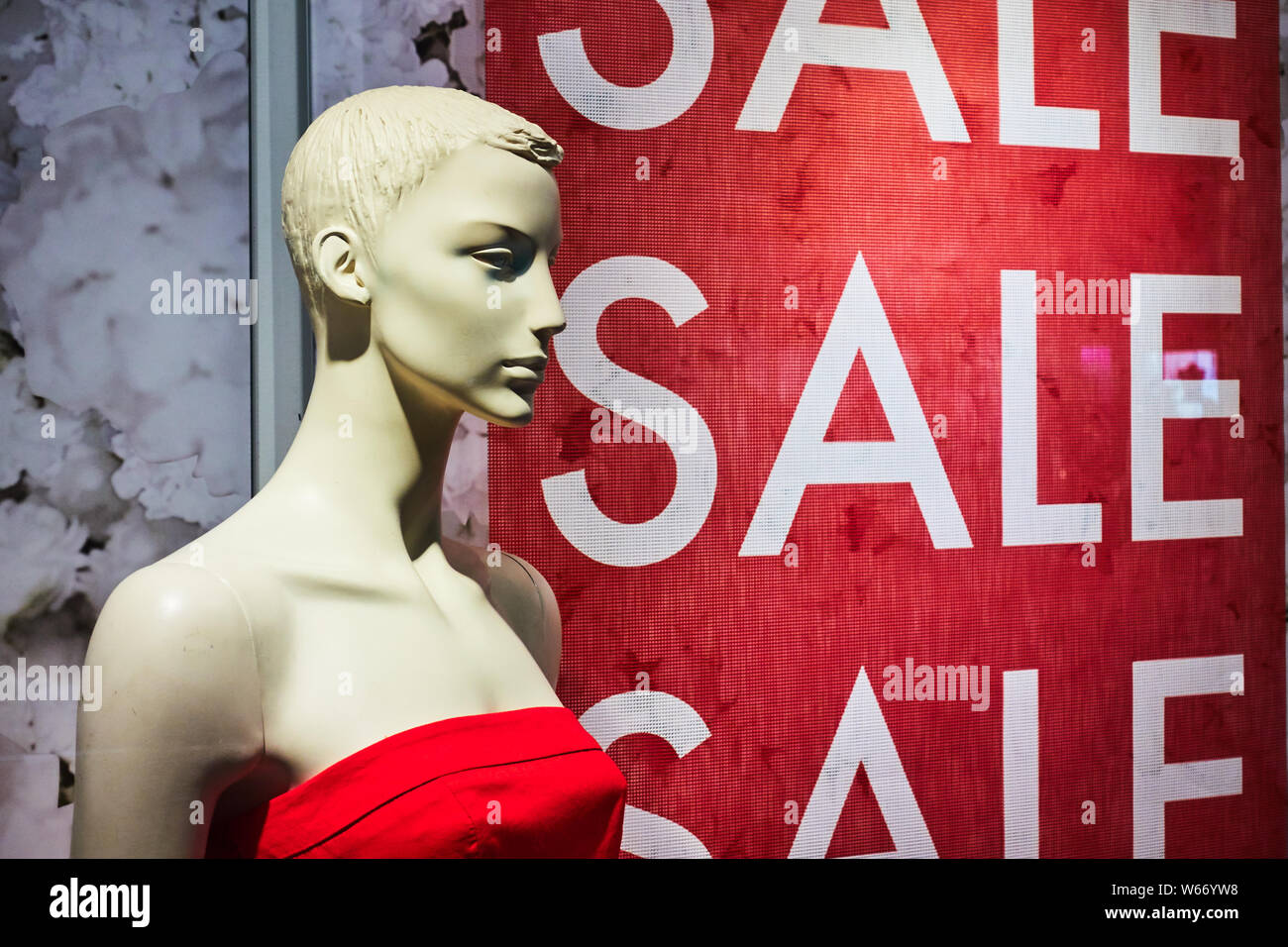 Female mannequin in a shop window on the background of the inscription sale  Stock Photo - Alamy