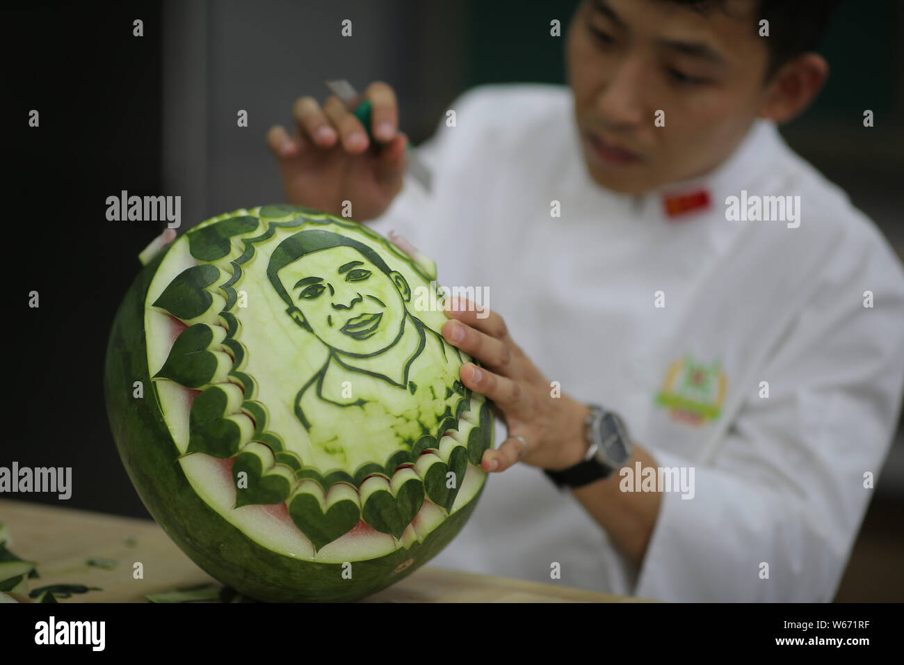 Chinese teacher Jiang Zhongmin shows watermelon carvings of French football player Kylian Mbappe in Shenyang city, northeast China's Liaoning province Stock Photo