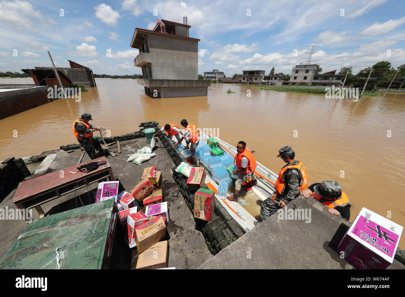 Chinese rescuers carry rescue relief to local residents trapped by floodwater caused by torrential rain in Qiaoxi village, Dongxiang district, Fuzhou Stock Photo