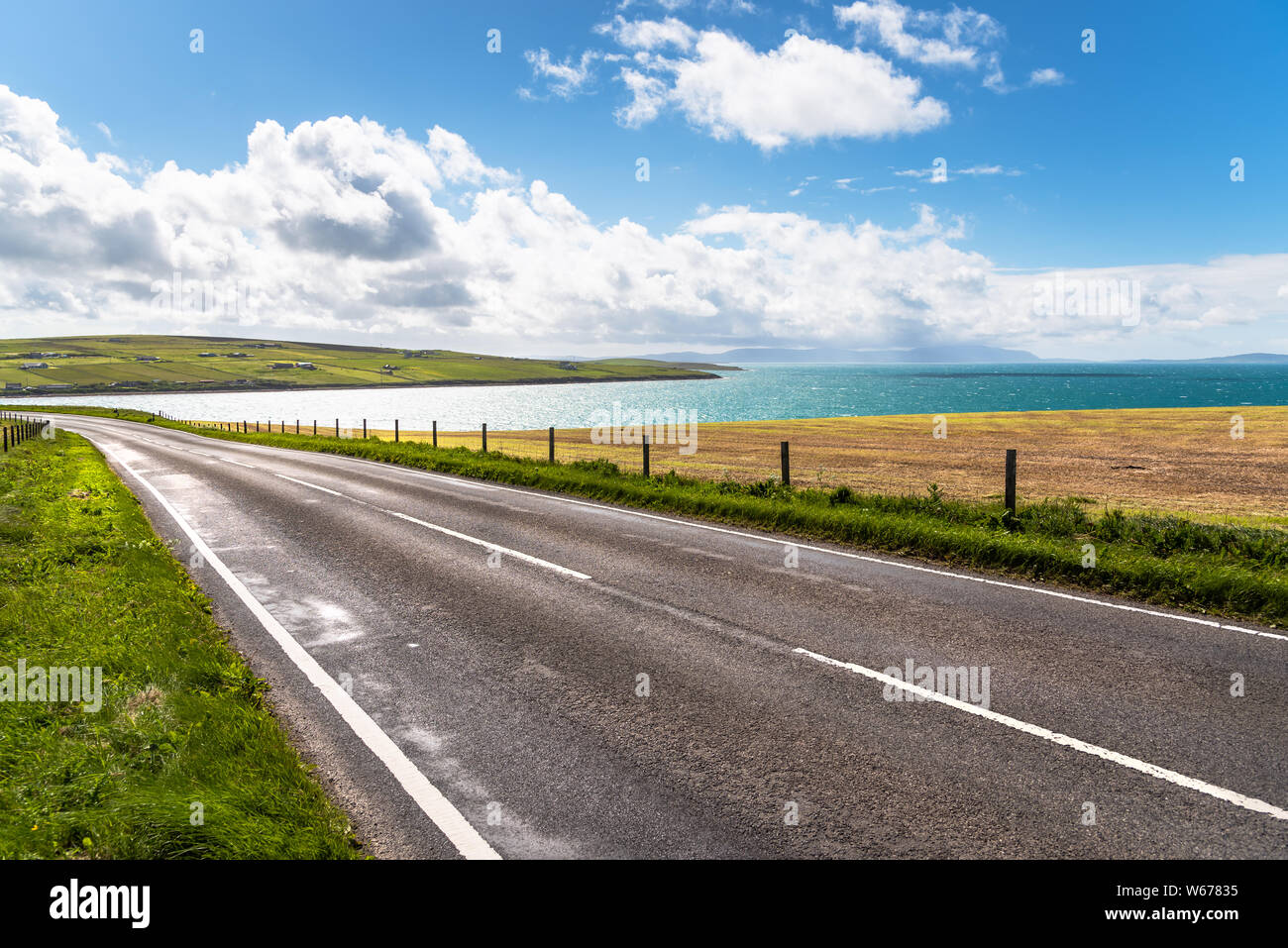 Deserted road running along a beautiful bay on a sunny summer day. Stock Photo