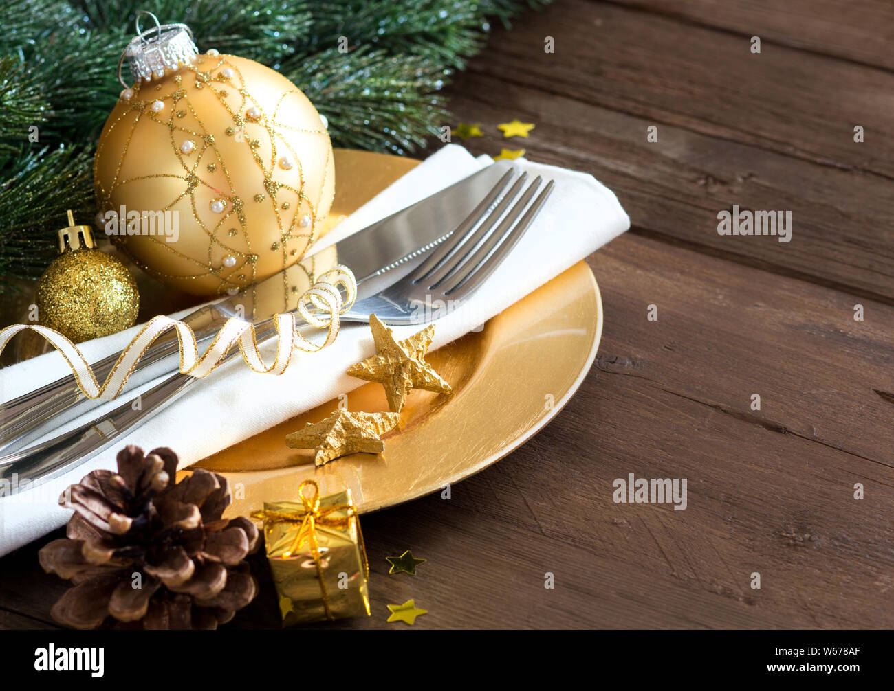 Festive table setting with golden bauble and plate Stock Photo - Alamy