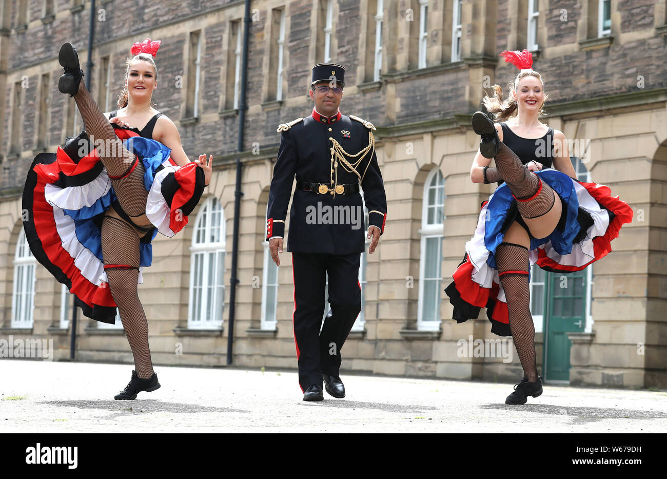 Adjutant chef Jean Michel Gatta from France is shown the Can Can dance by dancers Elia Roedaniel (left) and Caroline Drummond (right) as they take a break rehearsal during a rehearsal of the Royal Edinburgh Military Tattoo of 2019 at Redford Barracks in Edinburgh. The theme this year is Kaleidoscope and almost 1,200 cast members from all over the world are taking part. Stock Photo