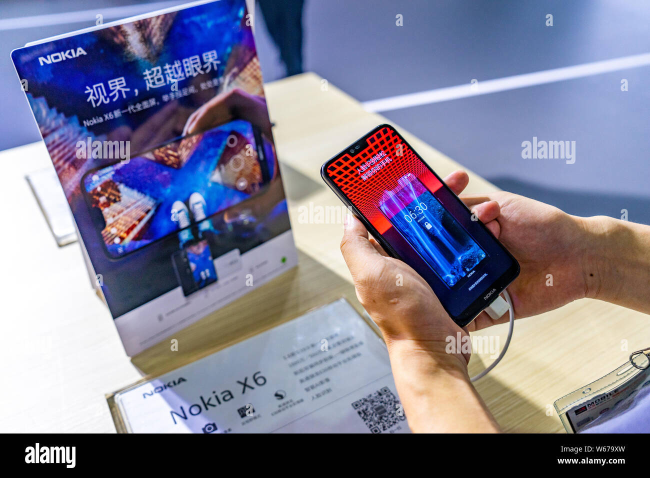 --FILE--A visitor tries out a Nokia X6 during the 2018 Mobile World Congress (MWC) in Shanghai, China, 29 June 2018.   Nokia Oyj and China Mobile Ltd. Stock Photo