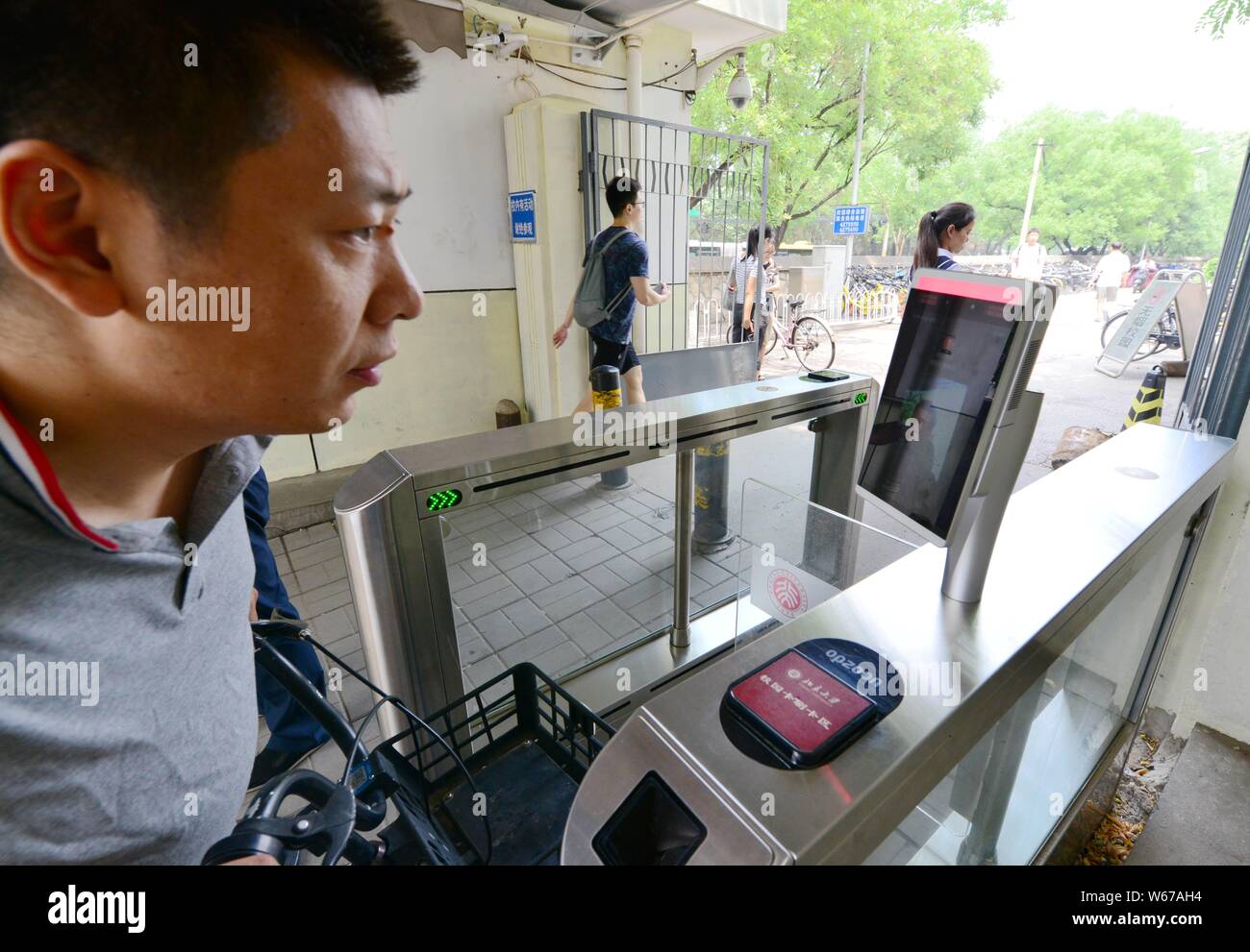 A student scans his face through a facial recognition system to enter a