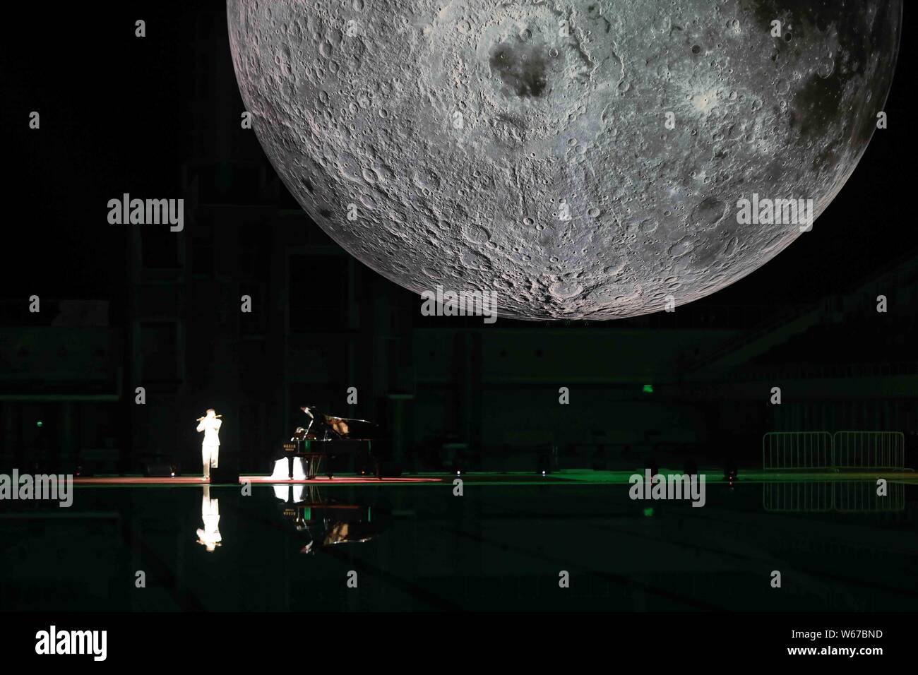 Visitors view a huge moon model during an exhibition on moon held at the National Aquatic Center or "Water Cube" in Beijing, China, 8 July 2018.    A Stock Photo