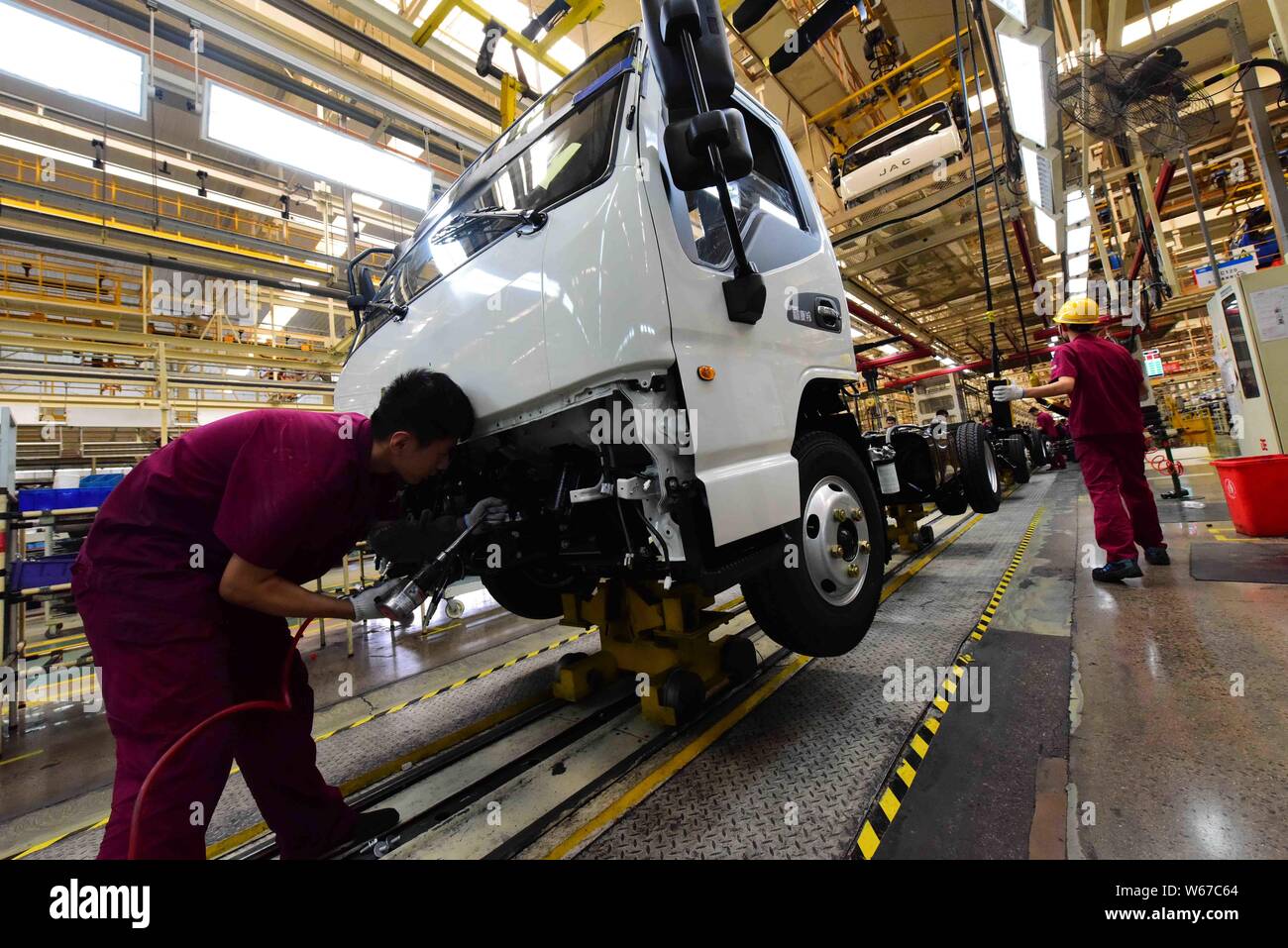 Chinese workers assemble cars on the assembly line at the auto plant of ...
