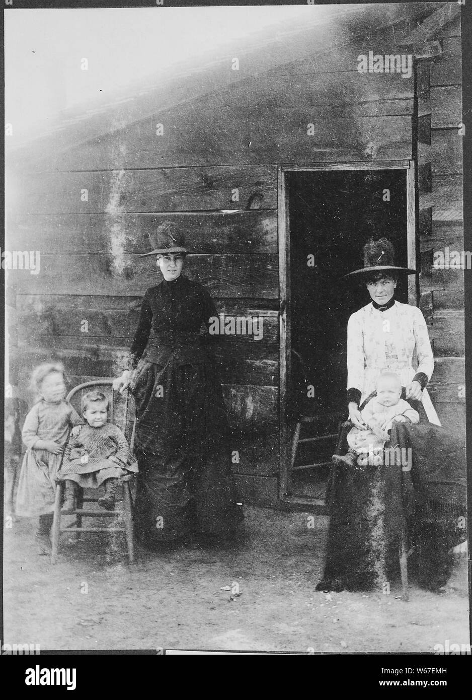 Mormons at Mormon Dairy. DESCR= Two women and their small children pose before a building at what is now known as Mormon Lake, Ariz. Terr. By E. A. Ames, 1887--89 Stock Photo
