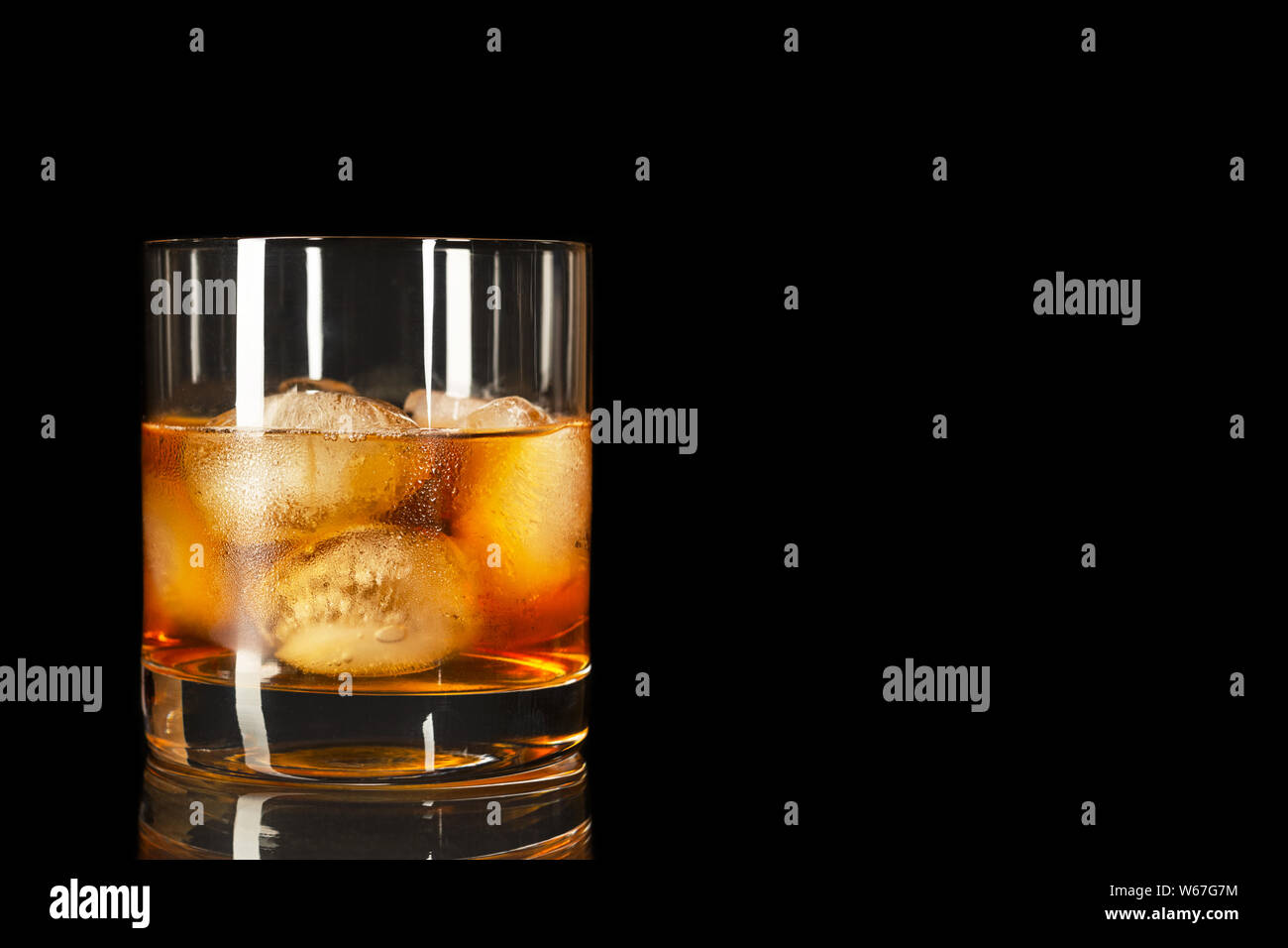 Bourbon snifter whiskey scotch glass on the black background, copy