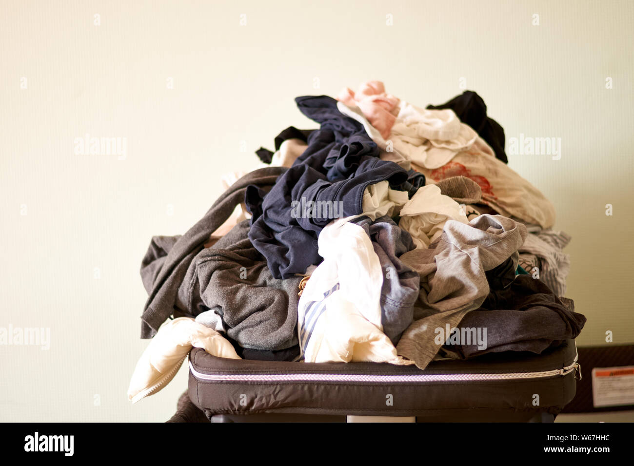Overflowing laundry at home. COpy space. Messy real life Stock Photo