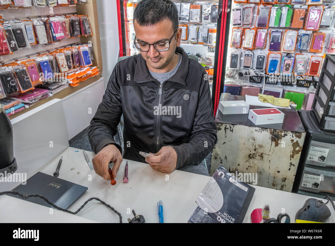Technician working on a faulty mobile telephone. Stock Photo