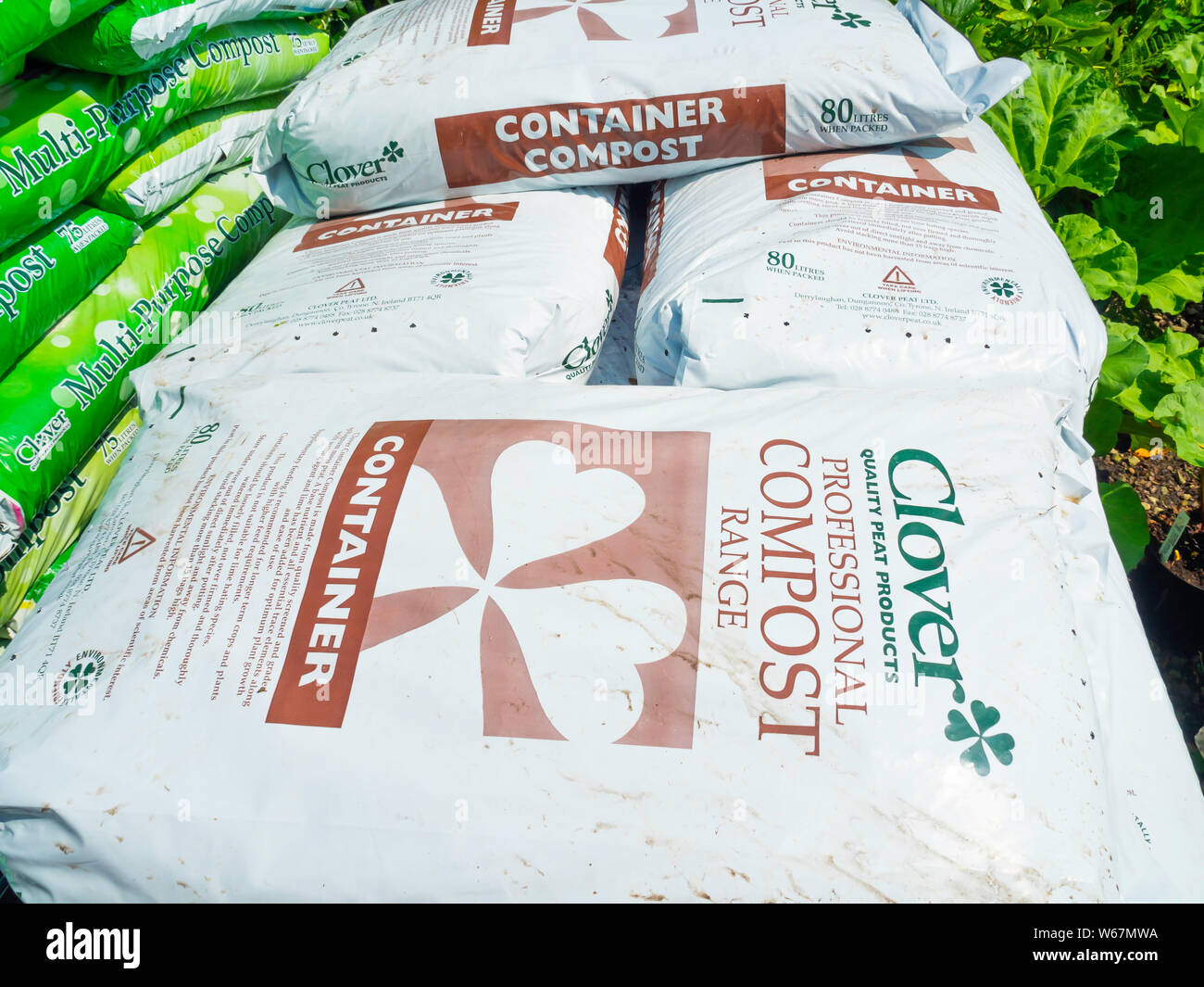 A Stack Of Bags Of Clover Brand Container Compost In A Garden