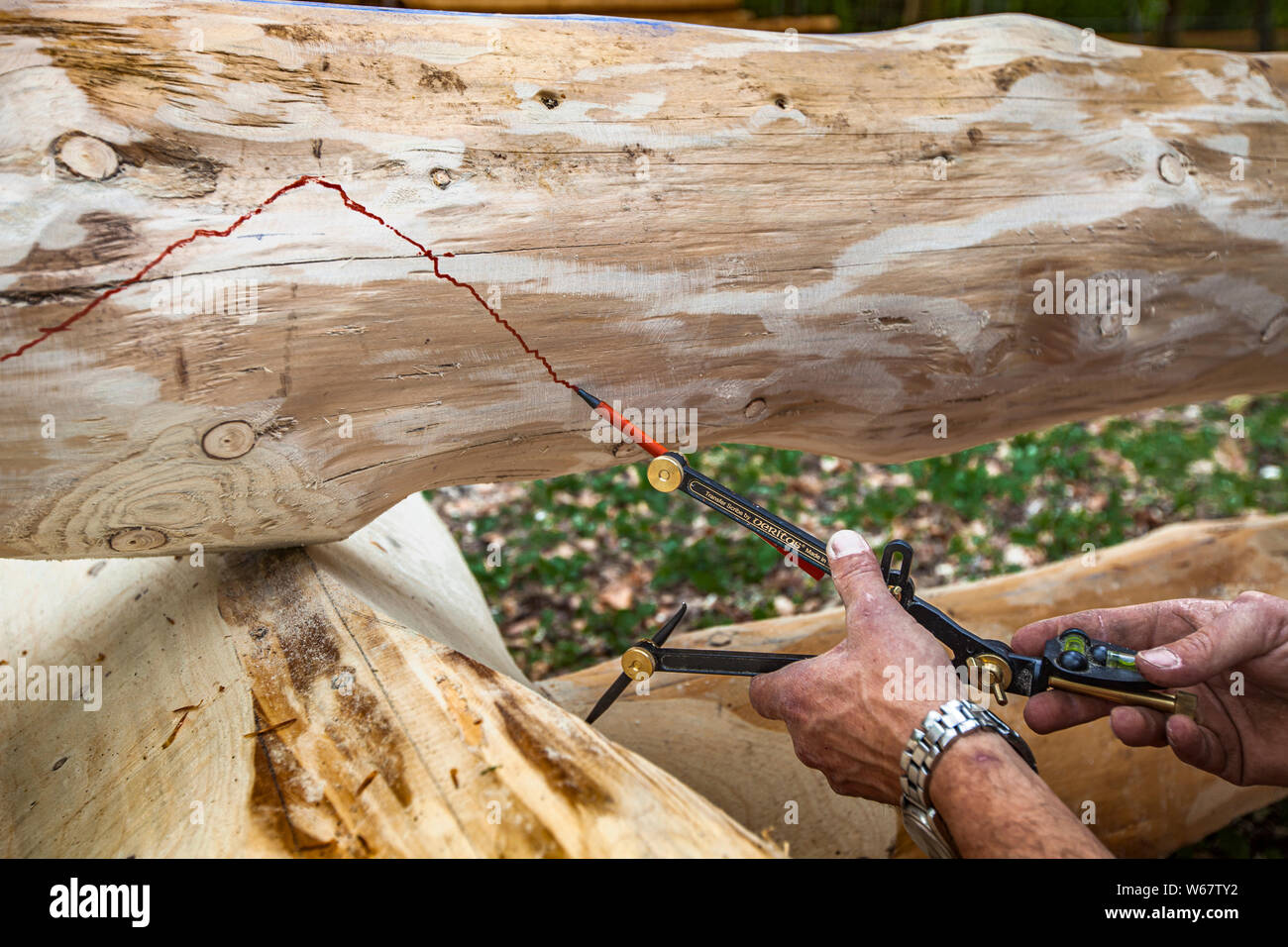 Building a log house with chainsaw and traditional carpenter tools in Grevenbroich, Germany Stock Photo
