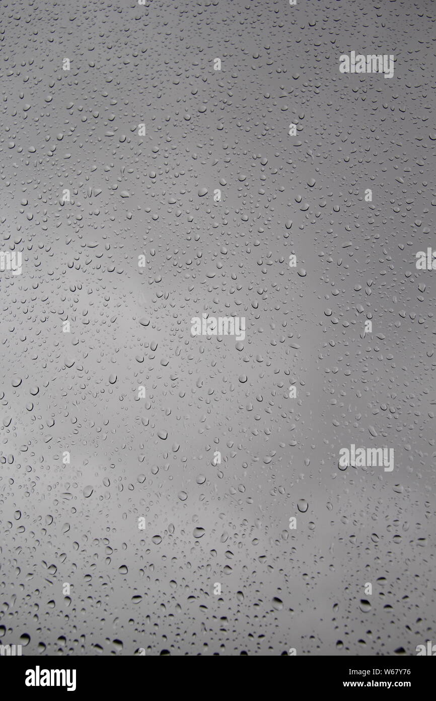 Raindrops on window-pane blurred background Stock Photo