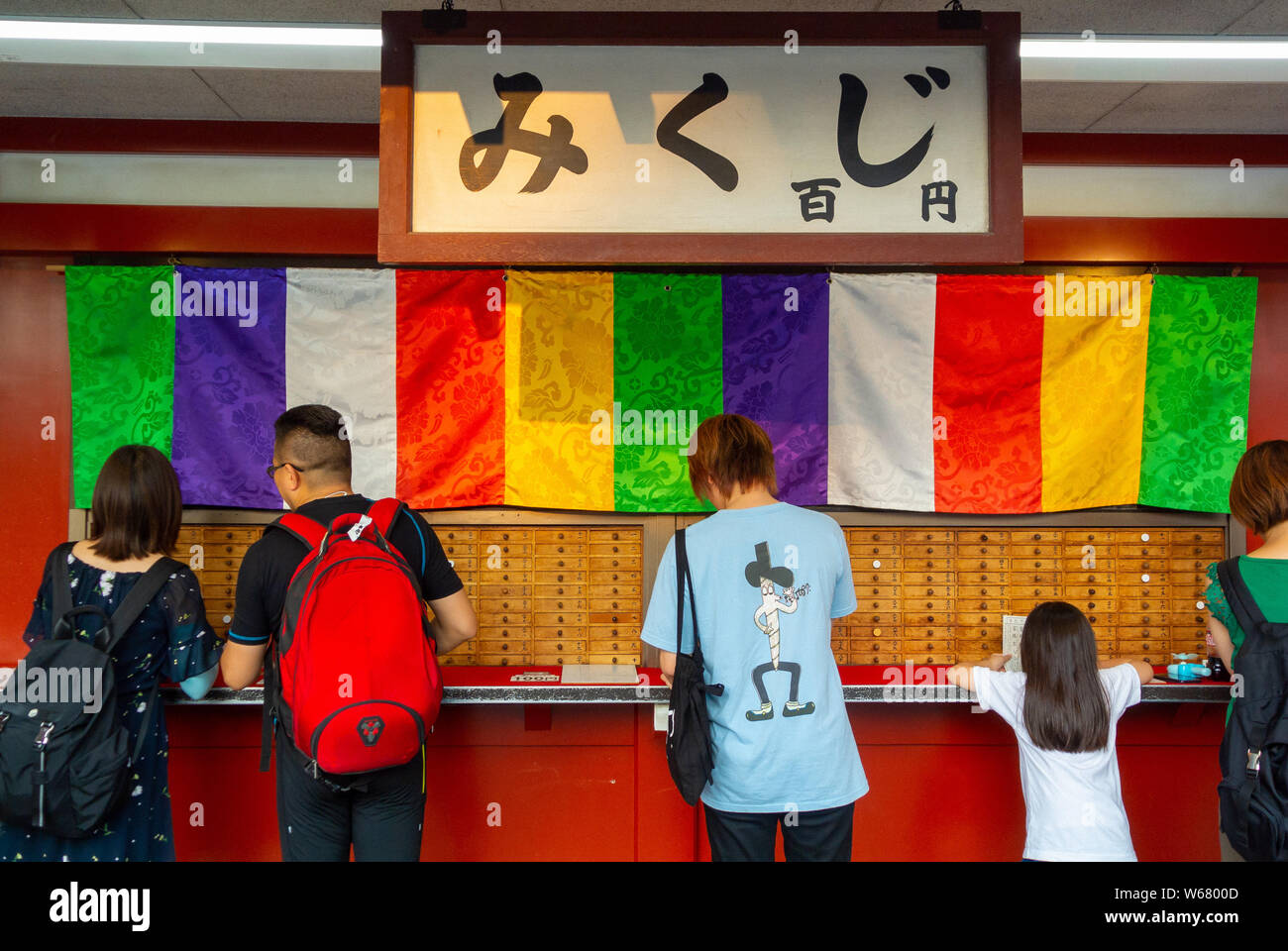 Tourist buying mikuji at Senso-Ji temple, Asakusa, Tokyo, Japan, 2019 Stock Photo