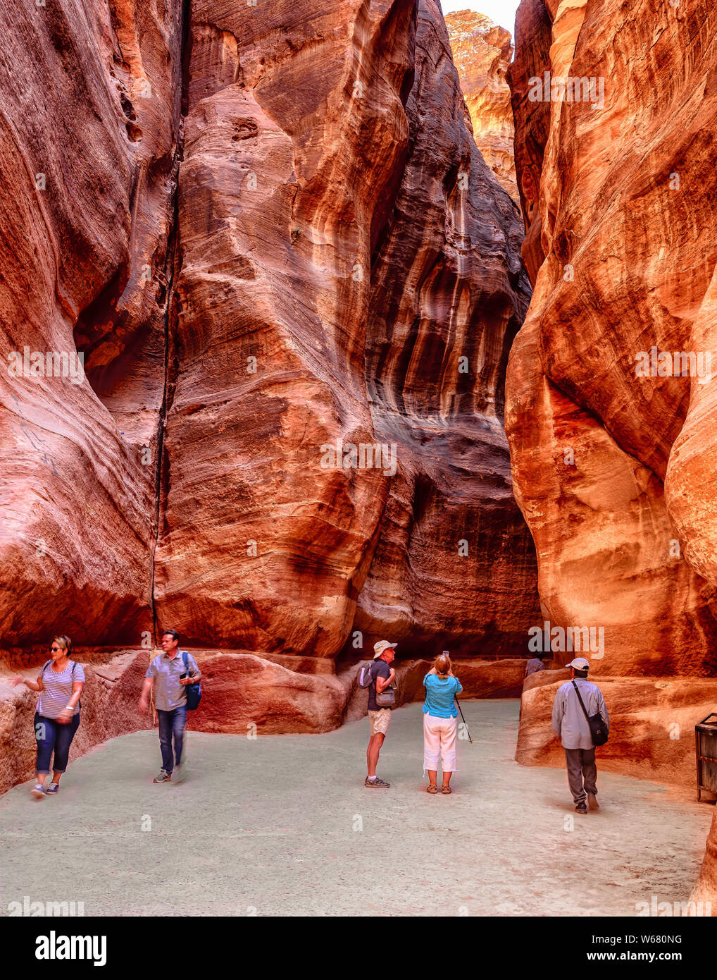 Tourists inside the Siq, the main entrance to the ancient Nabatean city of Petra in Jordan Stock Photo