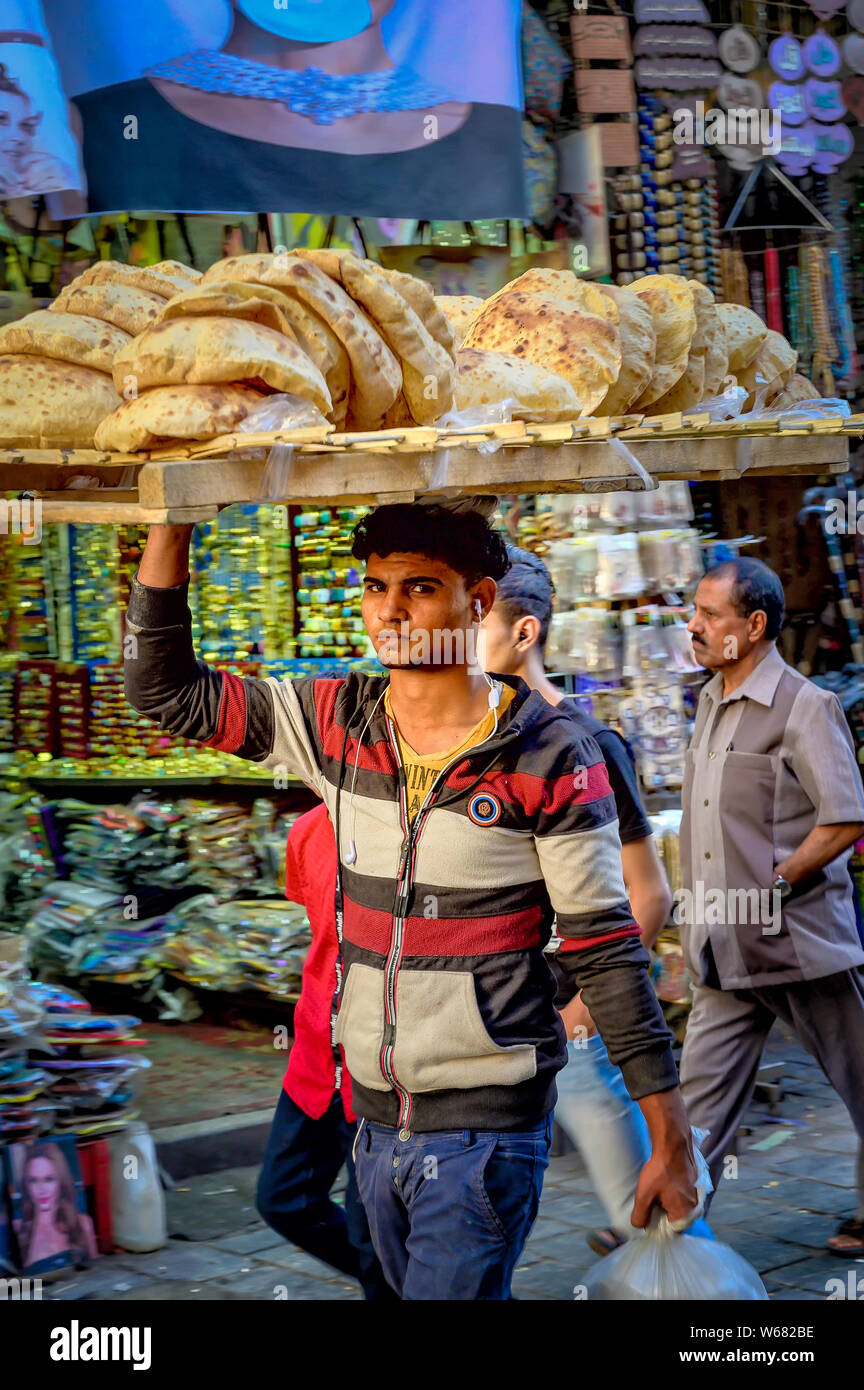 A young man transports bread in the streets of Khan El Khalili bazaar in Cairo Stock Photo