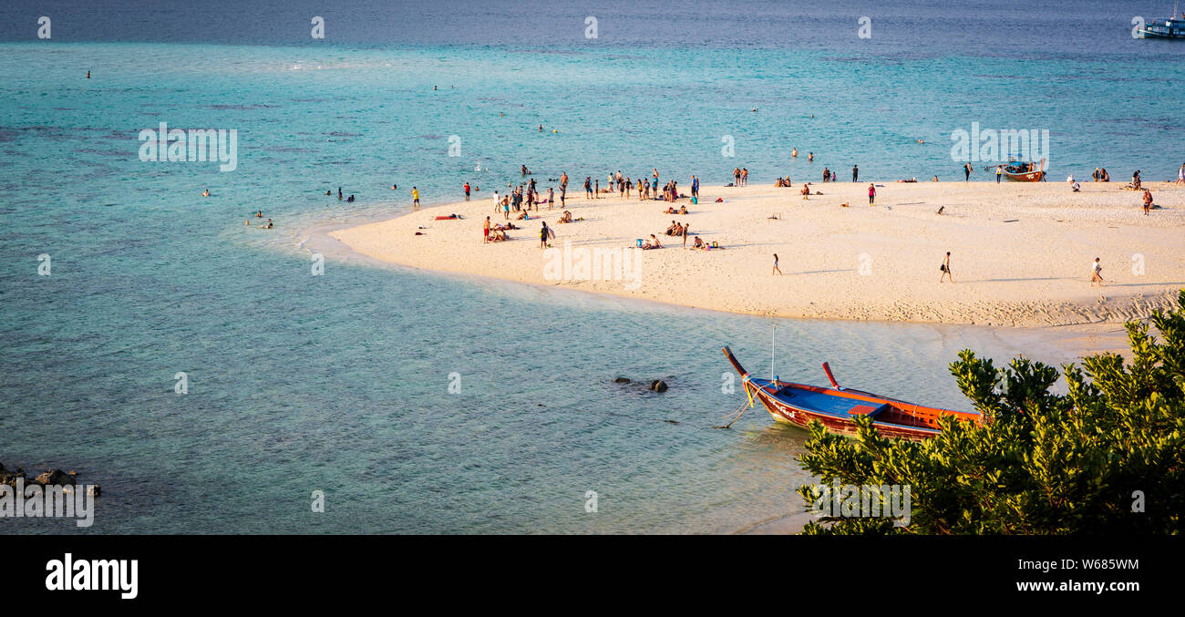 Several people on Sunrise beach on the island of Koh Lipe, Thailand Stock Photo