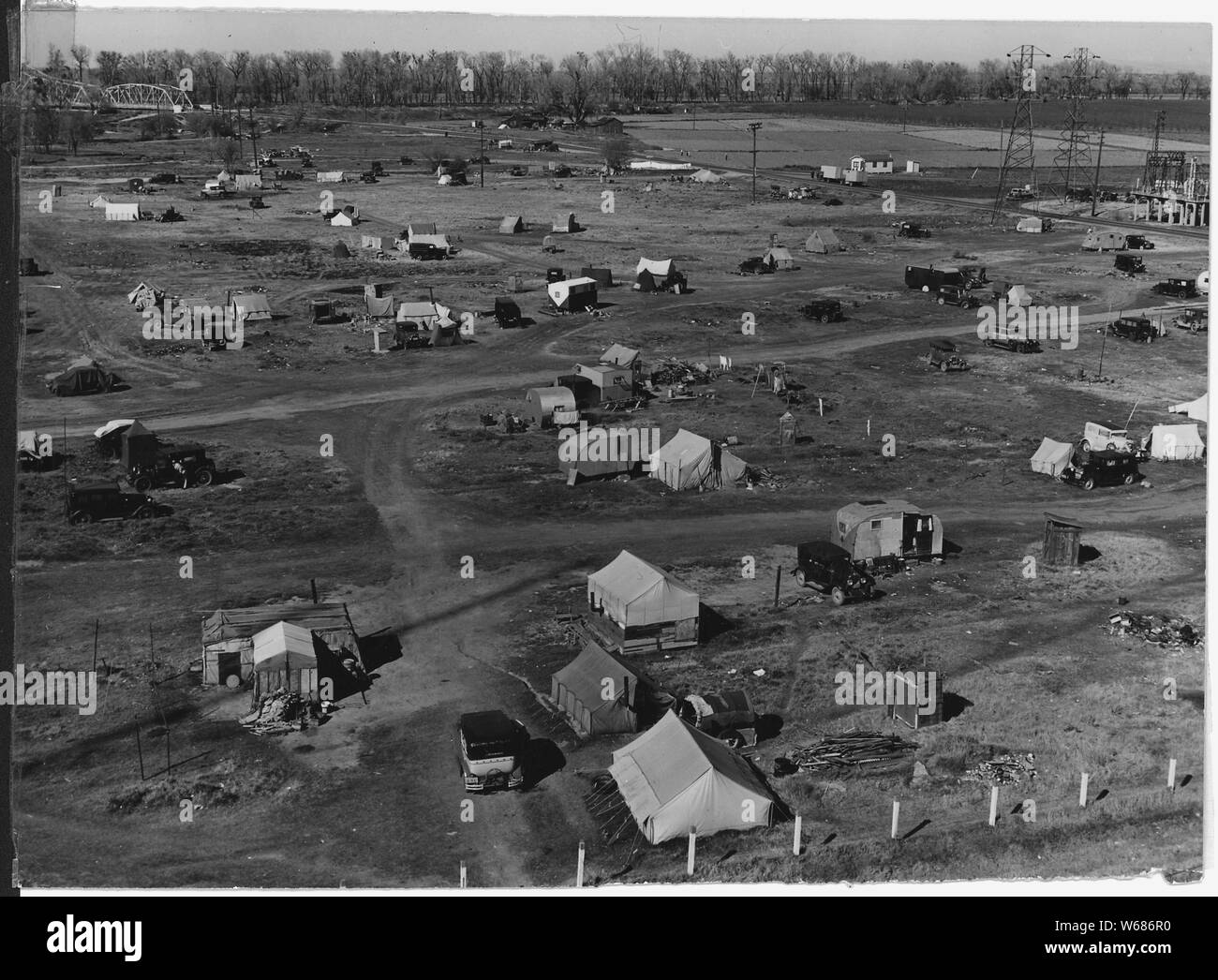 Sacramento, California. Squatter camp of agricultural labor migrants one-eighth mile outside city l . . .; Scope and content:  Full caption reads as follows: Sacramento, California. Squatter camp of agricultural labor migrants one-eighth mile outside city limits of State Capitol of California. Above 125 units, mostly families, without sanitation; water donated by power company from single faucet. Across the main road (upper right of panel) is a trailer camp. Beyond is a newly developing shack town community where lots are being sold and families are settling in makeshift home-built cabins and Stock Photo