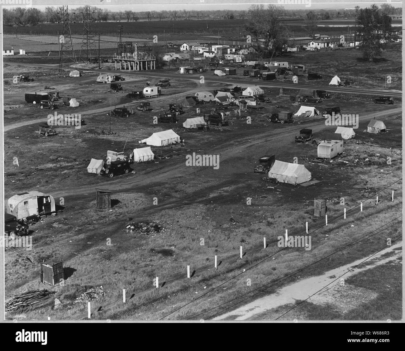 Sacramento, California. Squatter camp of agricultural labor migrants one-eighth mile outside city li . . .; Scope and content:  Full caption reads as follows: Sacramento, California. Squatter camp of agricultural labor migrants one-eighth mile outside city limits of state capital of California. Above 125 units mostly families without sanitation water donated by power company from single faucet. Across main road (upper right of picture) is a trailer camp. Beyond is a newly developing shacktown community where lots are being sold and families are settling in makeshift home-built cabins and cotta Stock Photo