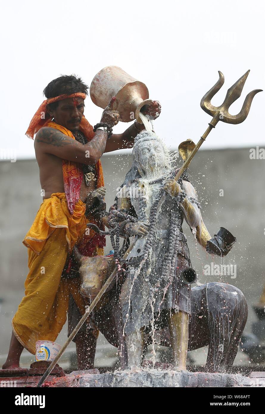 Kathmandu, Nepal. 31st July, 2019. A Hindu priest pours milk as he offers prayers to idol of Lord Shiva at Shiva temple during the holy month of Shrawan. Shrawan month is considered as the holiest month of the year to offer prayers to Lord Shiva for happiness and prosperity. Credit: Archana Shrestha/Pacific Press/Alamy Live News Stock Photo
