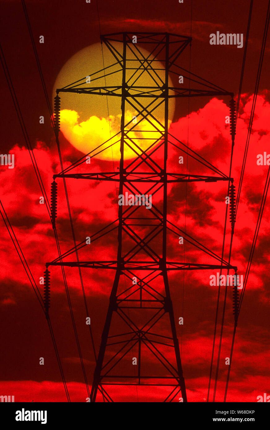 The afternoon sun as seen through some electical high tension wires (photogrphed through a red filter) Stock Photo