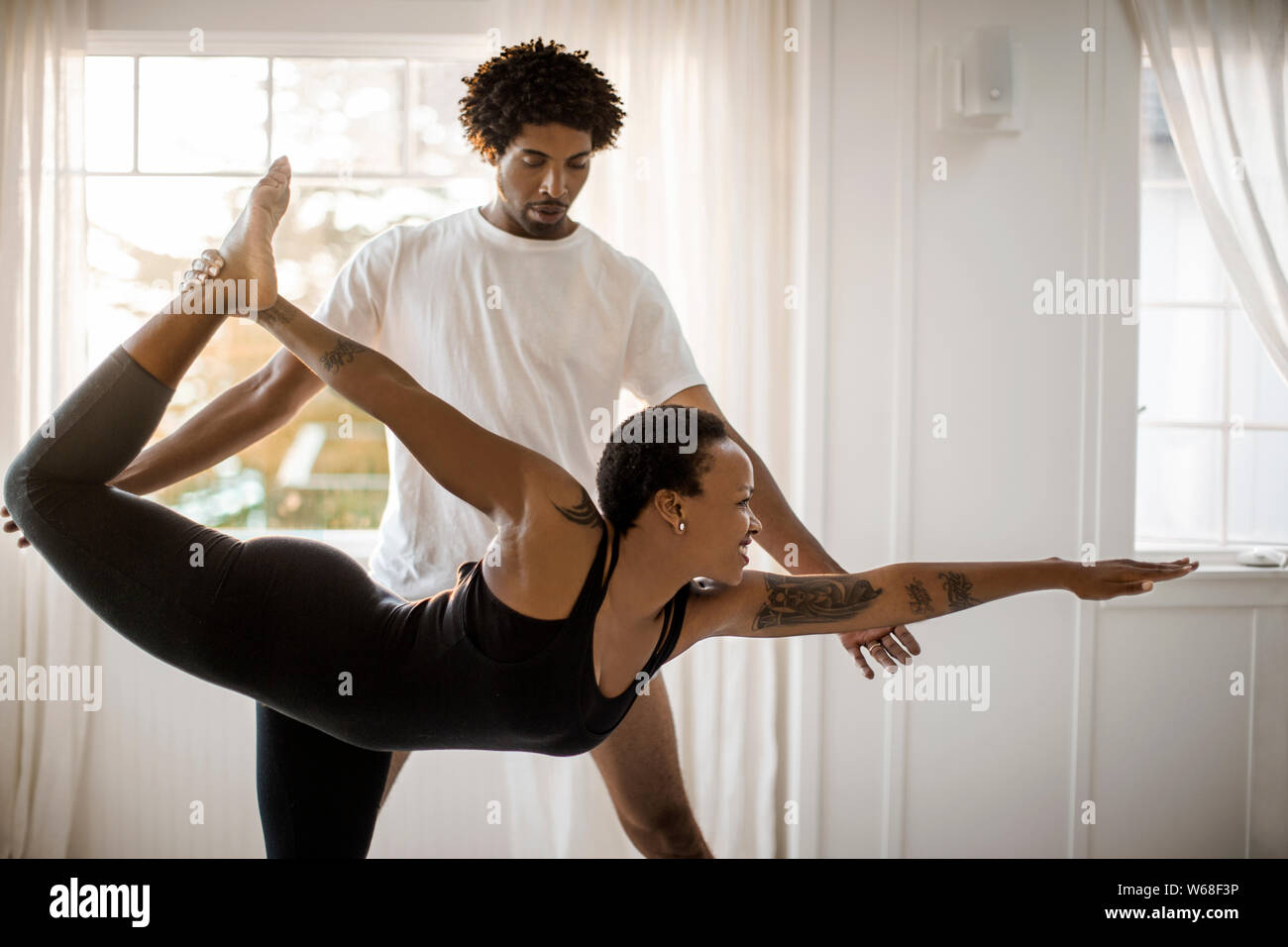 Woman practicing yoga with an instructor. Stock Photo